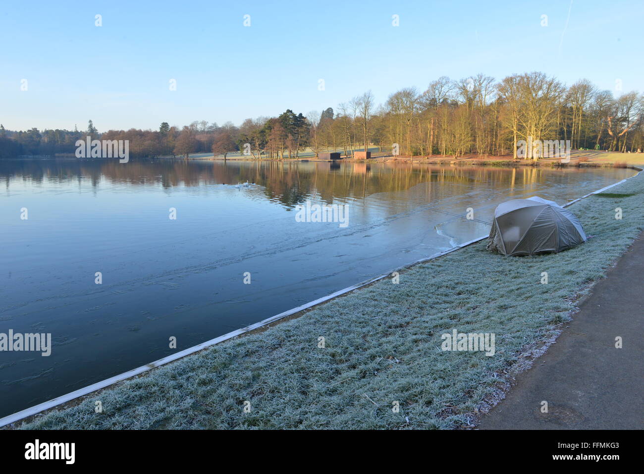 Un pescatore addormentato in un bivacco a lato di un lago in inverno, Foto Stock