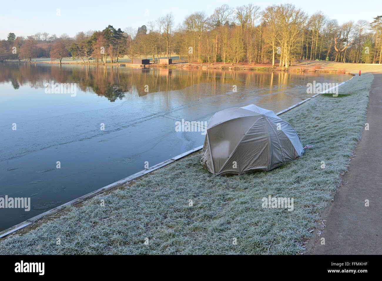 Un pescatore addormentato in un bivacco a lato di un lago in inverno, Foto Stock
