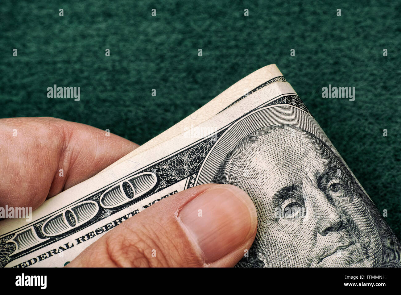 Persona detiene le fatture del dollaro nella sua mano su sfondo verde. Close up. Foto Stock