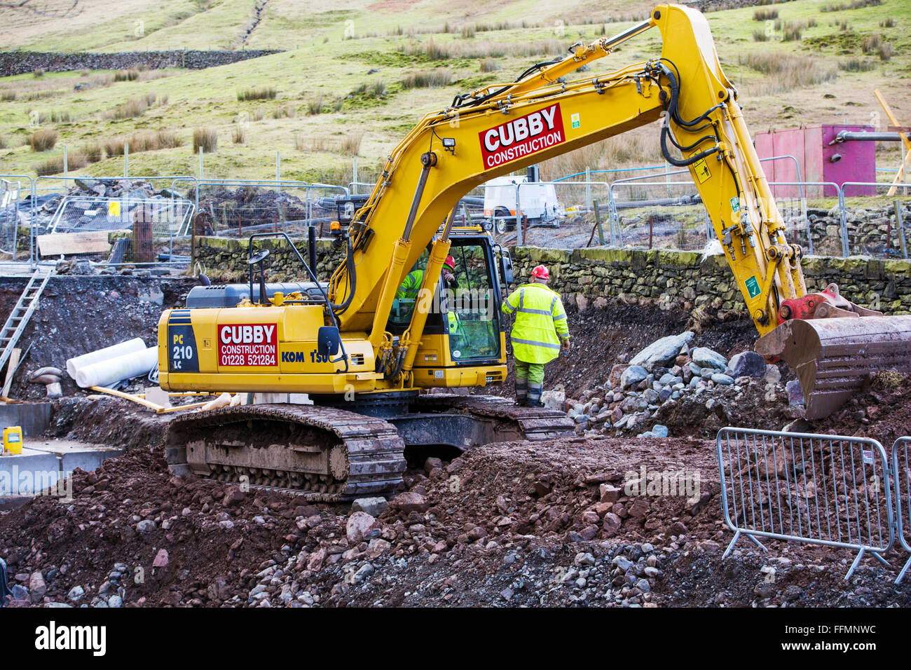 Tempesta Desmond causarono distruzione in tutto Cumbria con inondazioni e distruzione. L'A591, la strada principale tra Ambleside e Keswick è stato affettato in due, come grandi parti della strada sono stati spazzati via. È probabile che si tratti di sei mesi almeno prima che la strada è aperta. Questa foto mostra gli appaltatori che lavorano per cercare e ripristinare la strada. Foto Stock