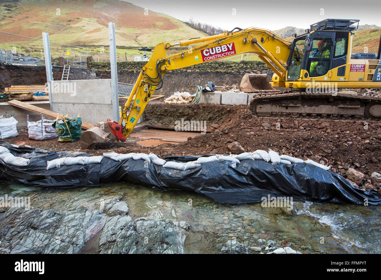 Tempesta Desmond causarono distruzione in tutto Cumbria con inondazioni e distruzione. L'A591, la strada principale tra Ambleside e Keswick è stato affettato in due, come grandi parti della strada sono stati spazzati via. È probabile che si tratti di sei mesi almeno prima che la strada è aperta. Questa foto mostra gli appaltatori che lavorano per cercare e ripristinare la strada. Foto Stock