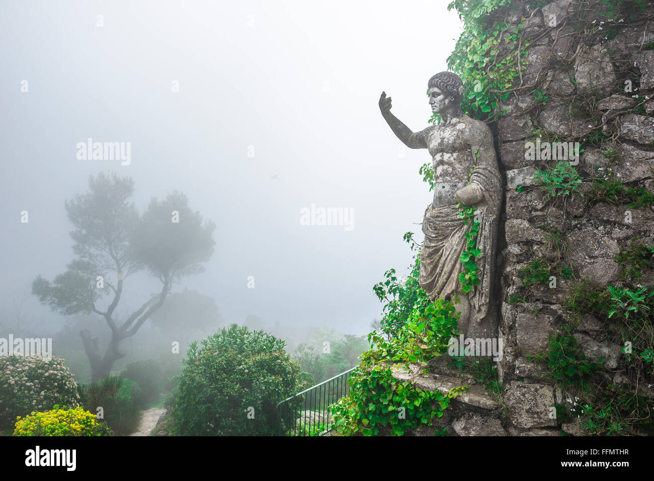 Monte Solaro Capri, inghirlandato nella nebbia di mattina una statua attira visitatori al giardino sul Monte Solaro, il punto più alto dell'isola di Capri, Italia. Foto Stock