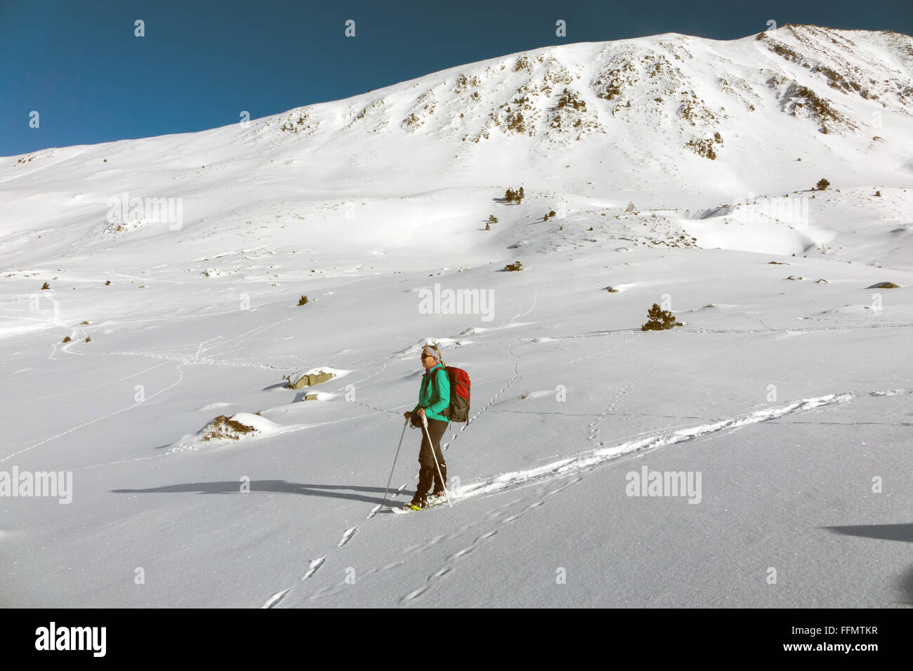 Figura femminile con le racchette da neve in Andorra montagne coperte di neve Foto Stock
