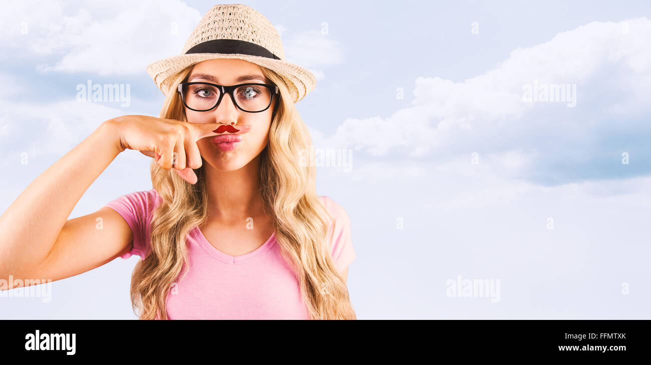 Immagine composita di una bella hipster avente un fake illustri i baffi Foto Stock