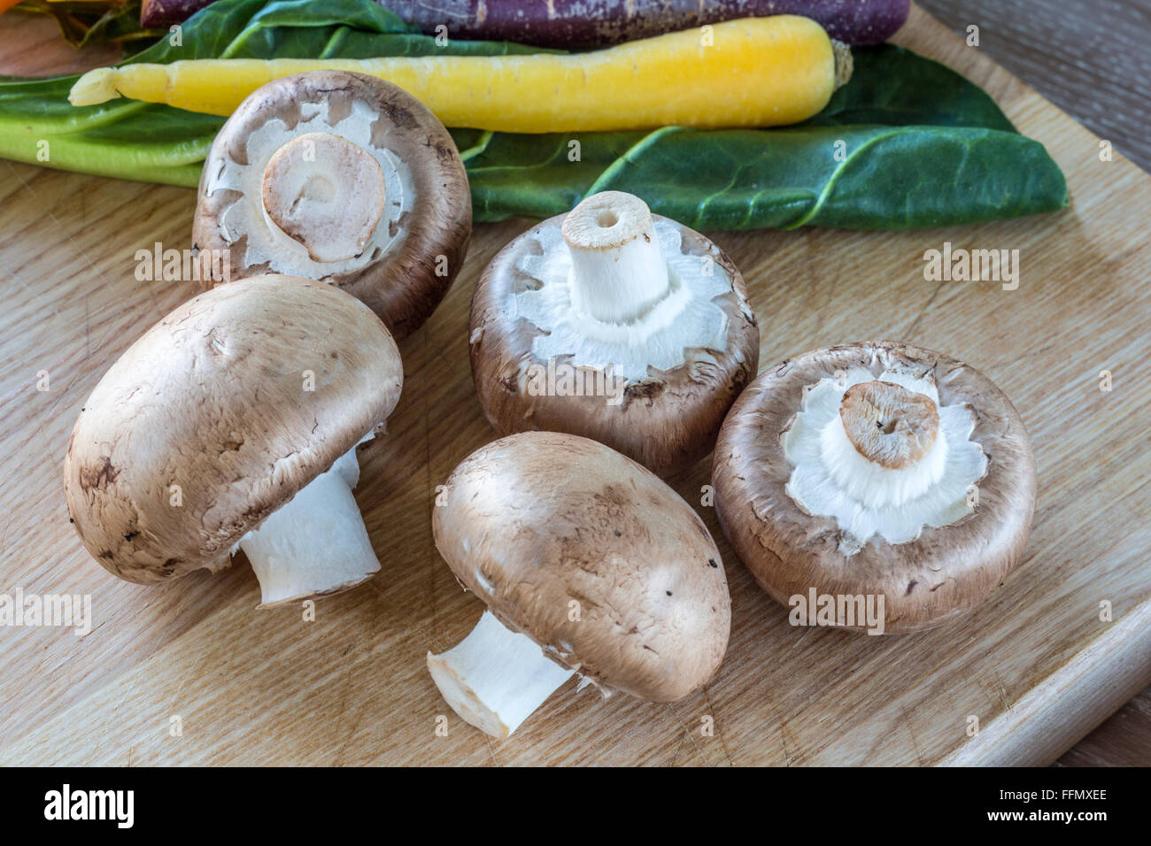 Funghi marrone con rainbow carote e bietole in background Foto Stock