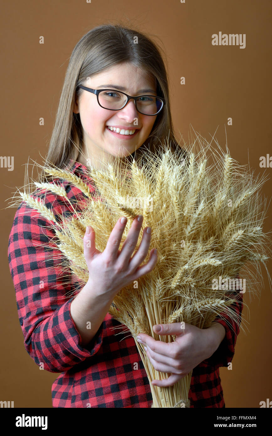 Ragazza tenere in mano mazzo di steli di grano riprese in studio Foto Stock
