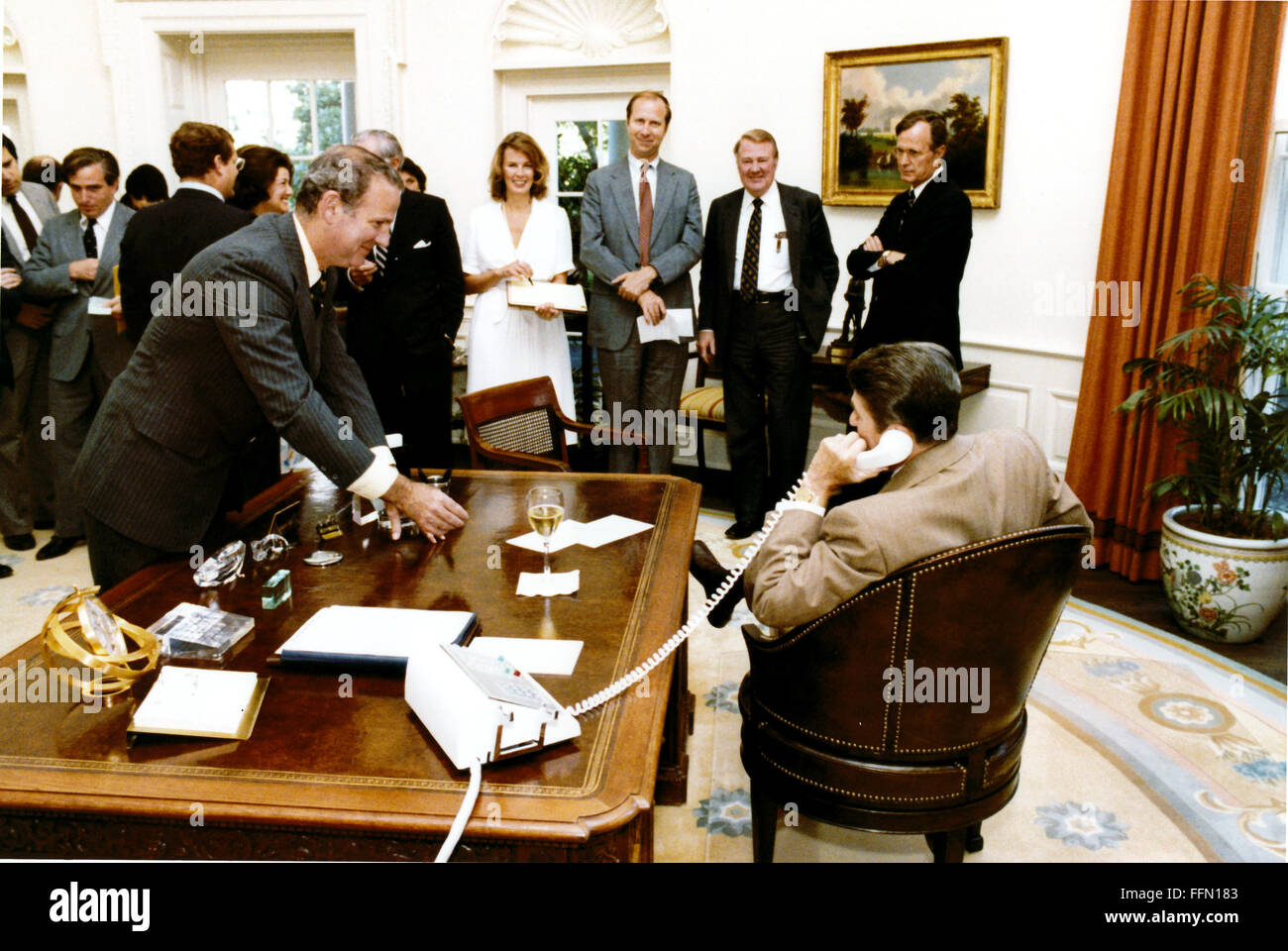 Nov. 22, 2009 - Washington, Distretto di Columbia, Stati Uniti d'America - il capo del personale della Casa Bianca, James A. Baker, III offre una vittoria un bicchiere di champagne per il Presidente degli Stati Uniti Ronald Reagan come egli parla all'altoparlante della casa Thomas P. ''Punta'' O'Neill al telefono in ufficio Ovale della Casa Bianca il mercoledì 29 luglio, 1981. I membri dello staff Karna piccole, David Gergen, Edwin Meese e Vice Presidente George H.W. Bush a guardare..Mandatory Credit: Michael Evans - White House via CNP (credito Immagine: © Michael Evans/CNP via ZUMA filo) Foto Stock