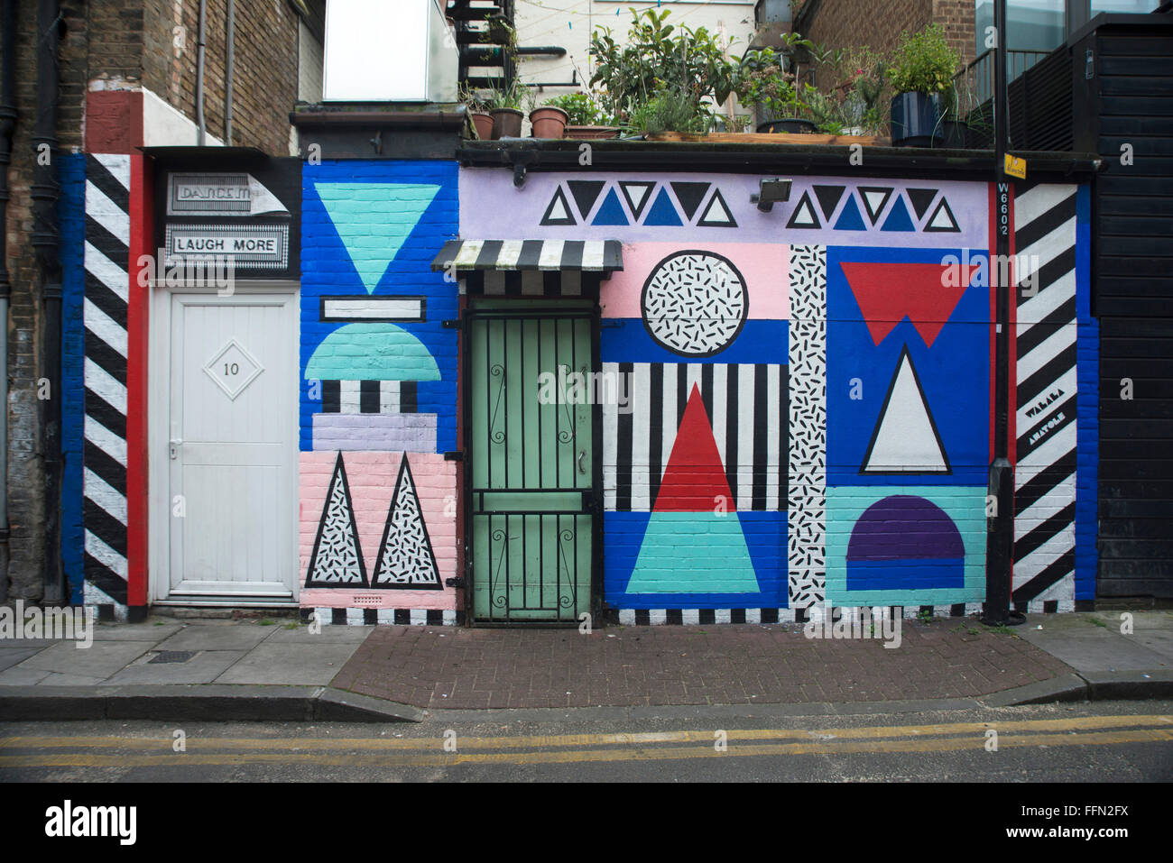 Shoreditch e Hoxton area street art di Londra. Un edificio esterni dipinti con un coloratissimo murale geometrico. Foto Stock