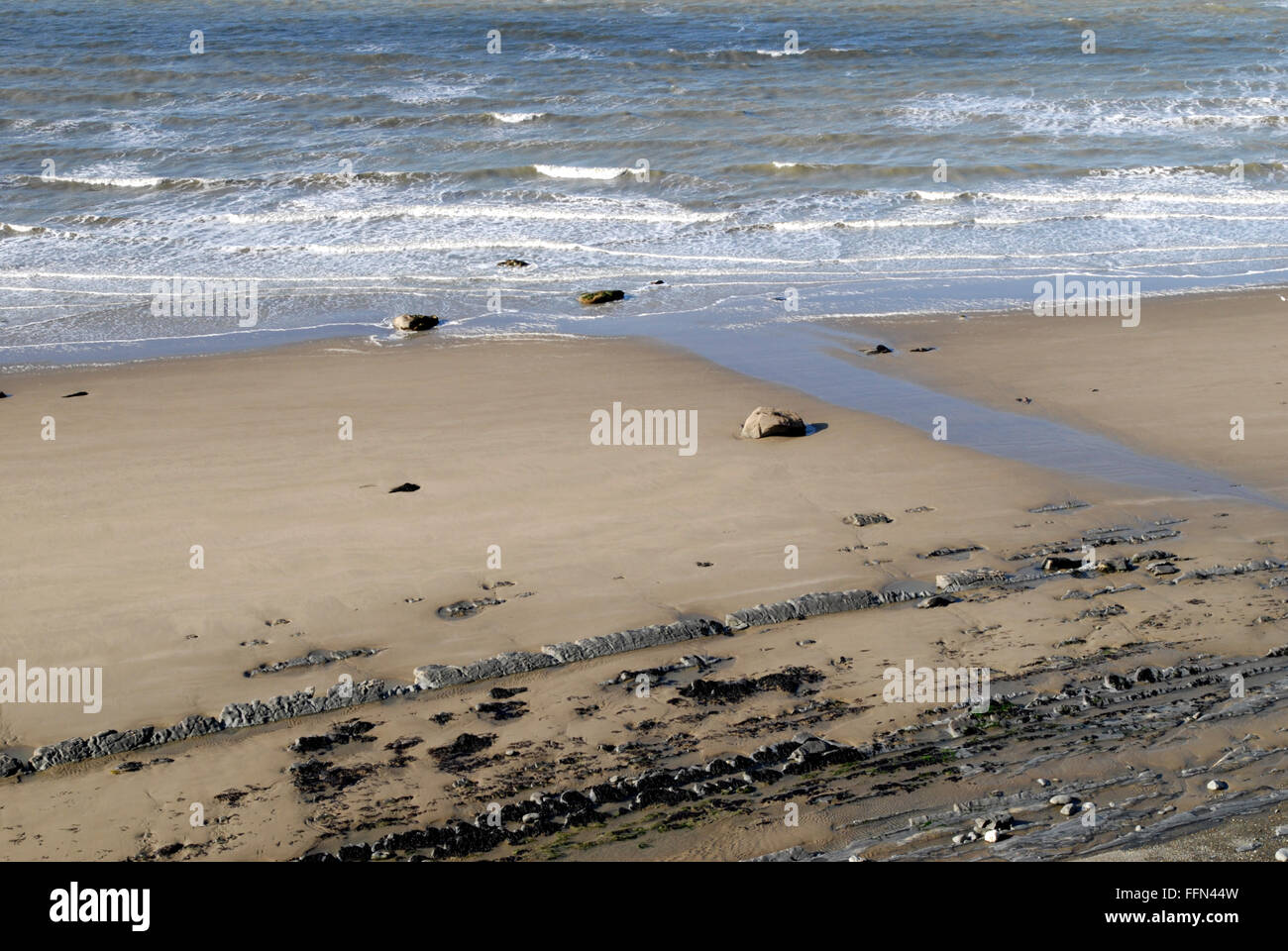 Sabbia e mare con interessanti formazioni rocciose. Visto dal Ceredigion sentiero costiero vicino al Sarn Cynfelin Causeway. Foto Stock