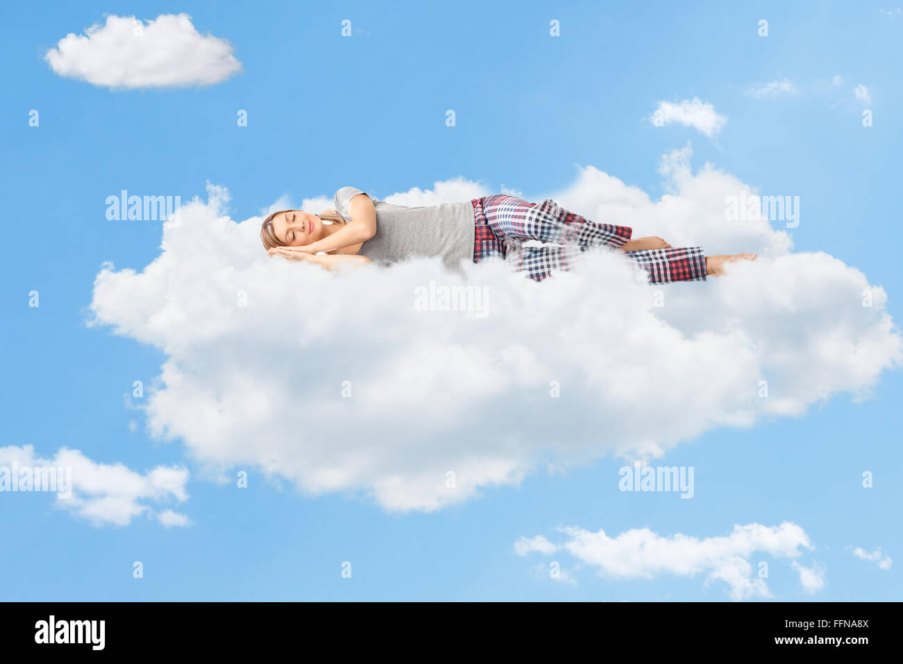 Tranquilla scena di una giovane donna di sognare e di dormire su una nuvola in cielo Foto Stock