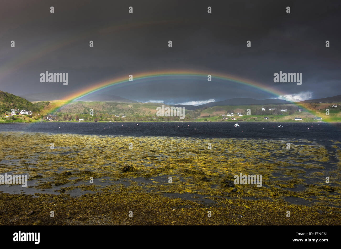 Rainbow su uig bay con drammatica dark sky da riva durante le tempeste Foto Stock