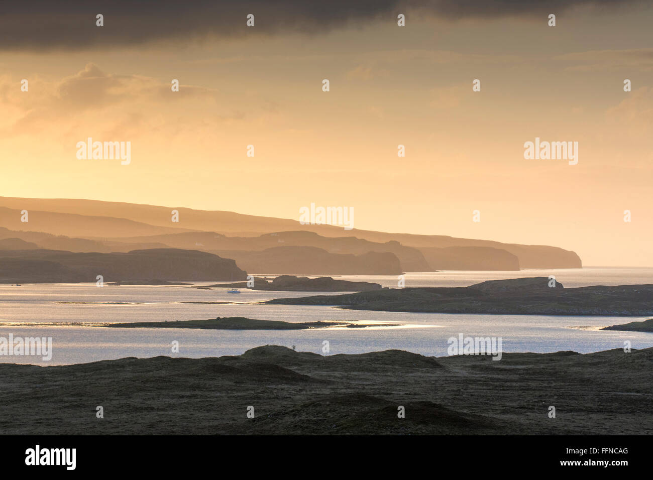 Loch dunvegan al tramonto con scogliere alte scogliere e gradazione dorata con isolette Foto Stock