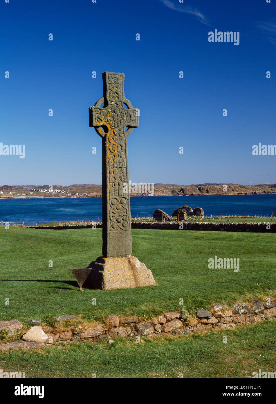 Faccia ovest di St Martin's C8th secolo Celtic alta croce accanto alla strada dei morti, Iona. Rovine di St Mary's Chapel & Sound di Iona verso la parte posteriore. Foto Stock