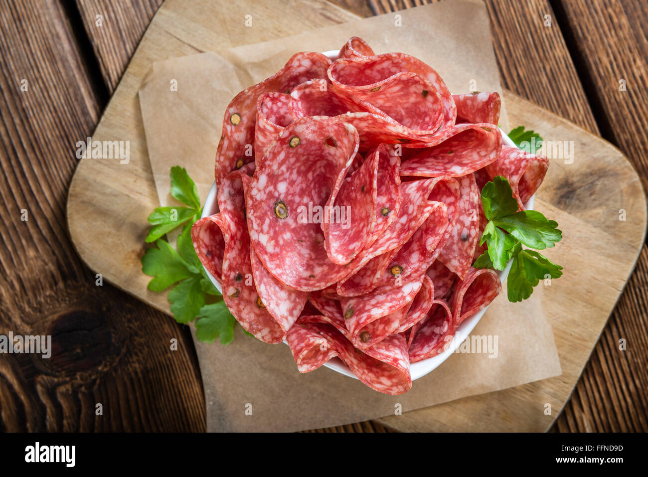 Salame affumicato (messa a fuoco selettiva) su un vecchio vintage tavolo in legno Foto Stock