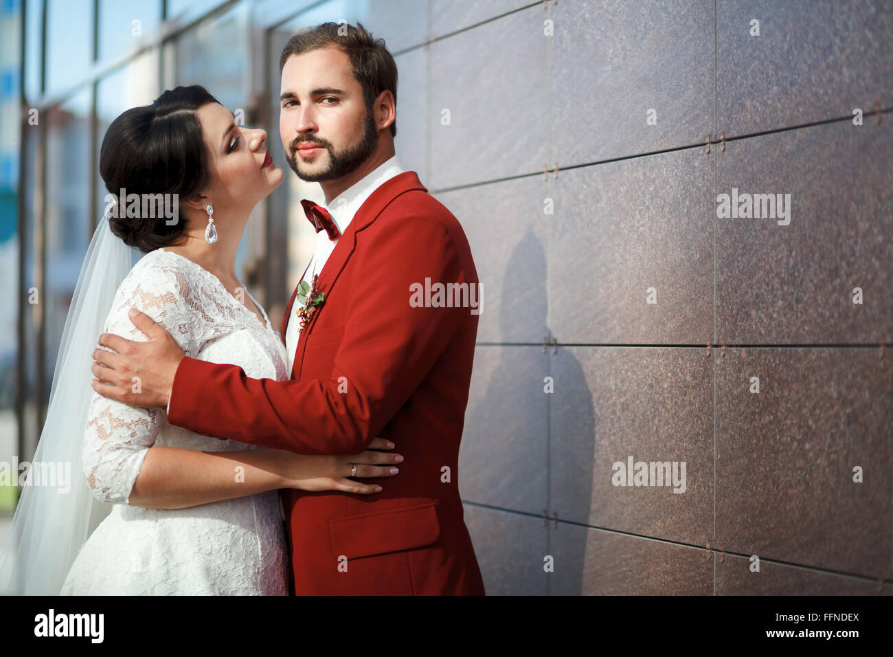 Sposa e lo sposo, romantiche coppie in viaggio di nozze in un impeto passionale, vicino le pareti dell'edificio. Foto Stock