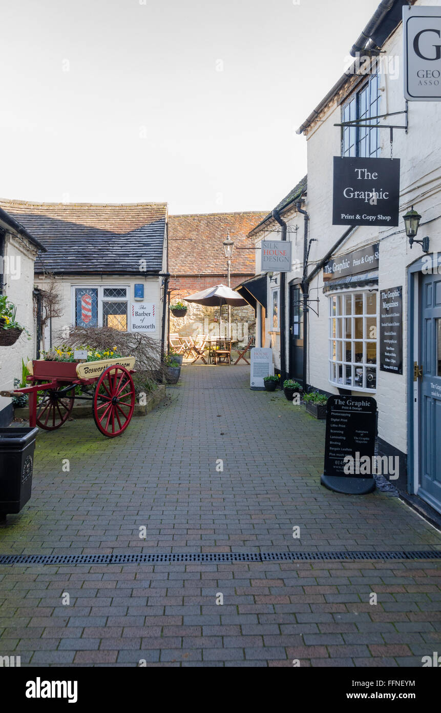 Negozi e cafè nel passaggio fuori strada principale nel mercato Bosworth, Leicestershire Foto Stock