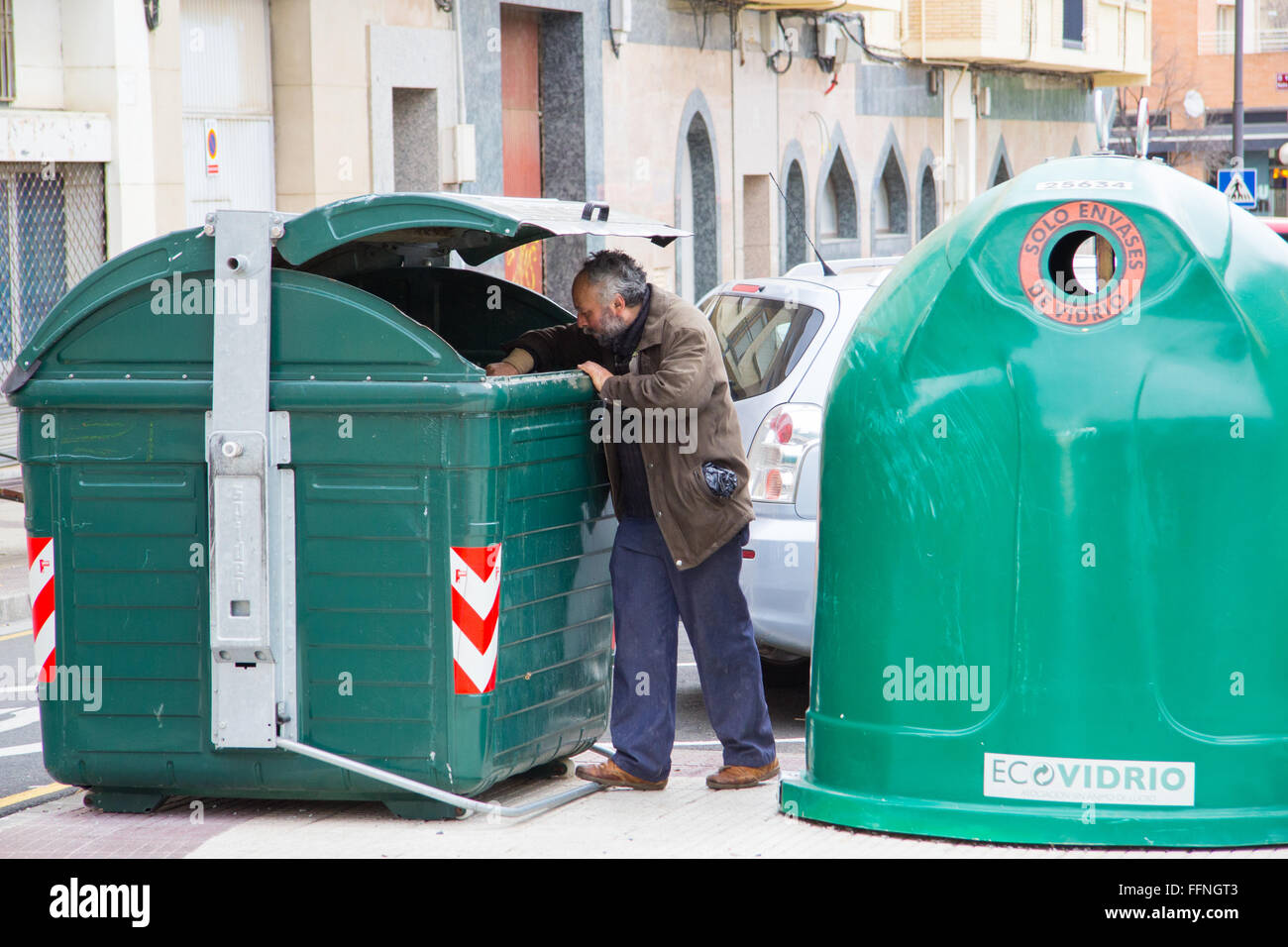 Un uomo cerca di cibo all'interno di un cassonetto in Logroño, Spagna Foto Stock