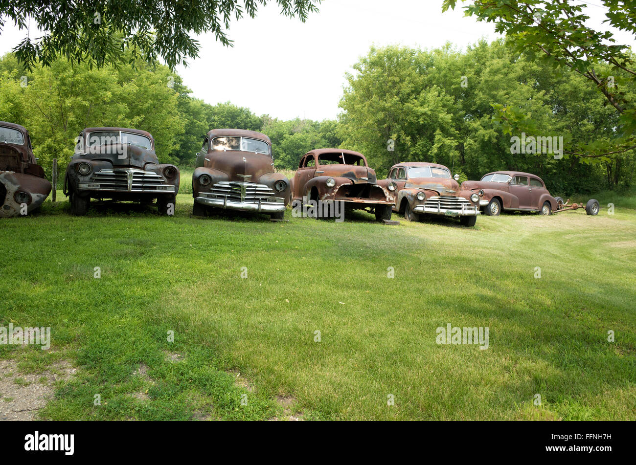 Lineup di vecchia ruggine di vetture in un cantiere residenziale. Fergus Falls Minnesota MN USA Foto Stock