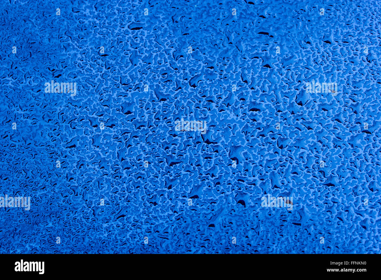 Gocce d'acqua su auto blu vernice come sfondo Foto Stock