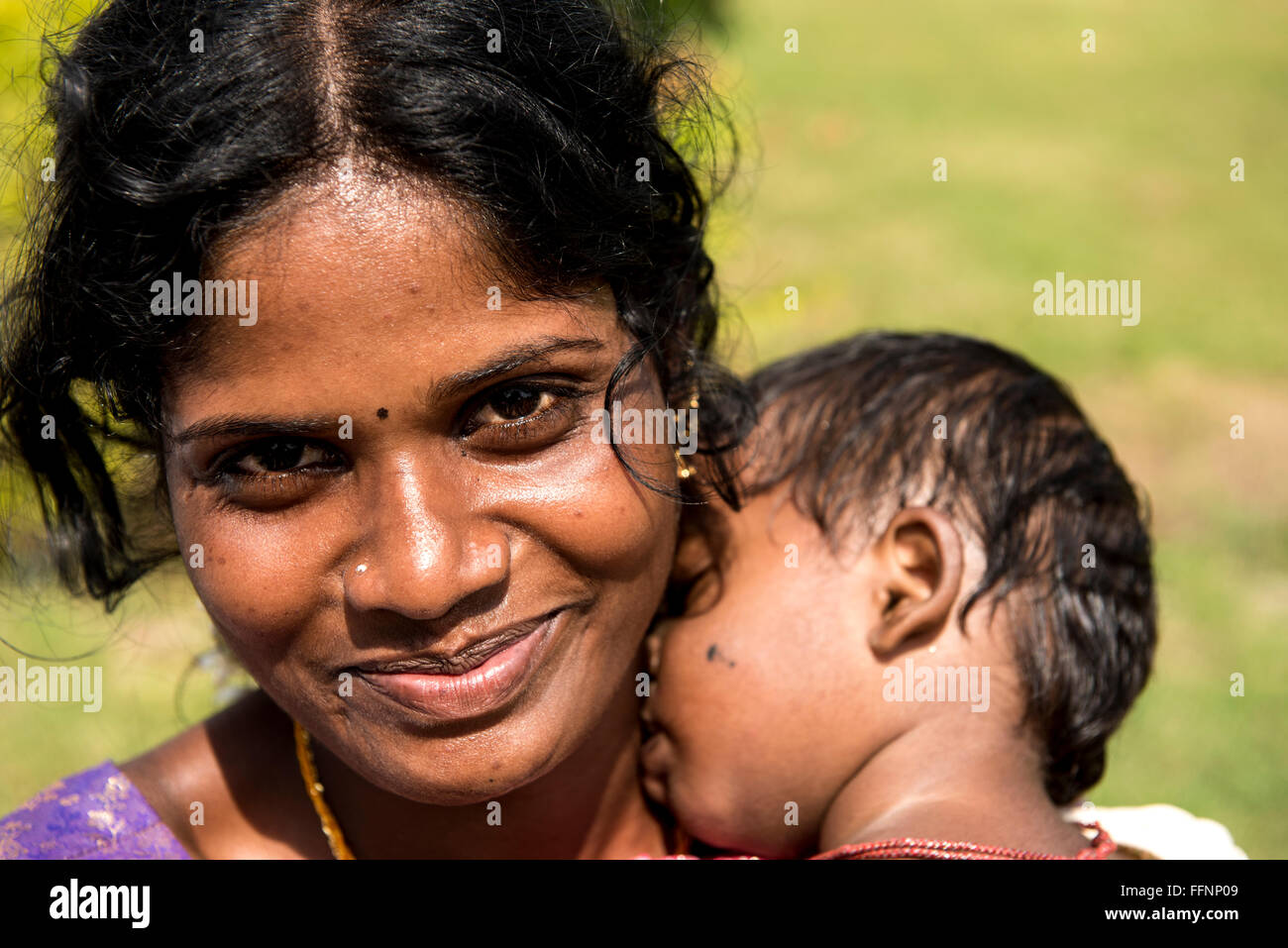 Donna indiana con il bambino addormentato sulla sua spalla in Tamil Nadu, India, Asia Foto Stock