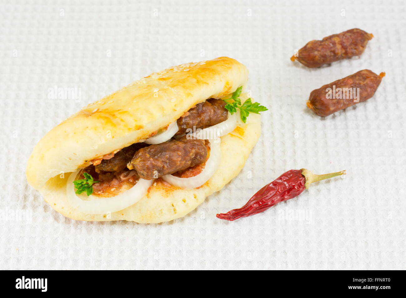 Spicy gourmet sandwich con piccoli particolari salsicce sulla tovaglia bianca Foto Stock