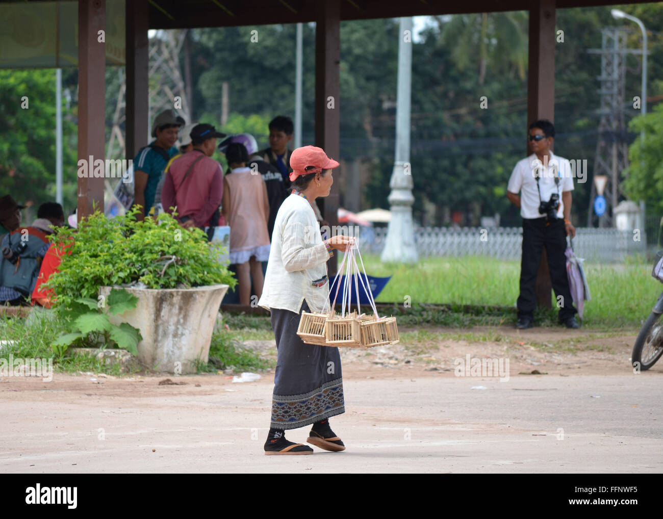 Sud-est asiatico donna vendita di uccelli a That Luang Foto Stock