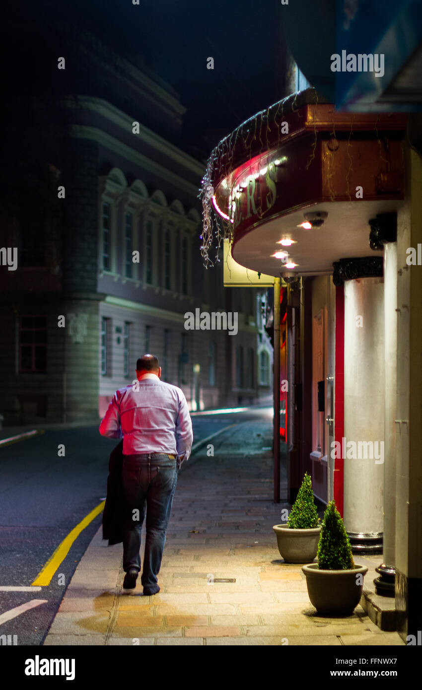 Uomo ubriaco in strada al di fuori di un pub al momento della chiusura Foto Stock