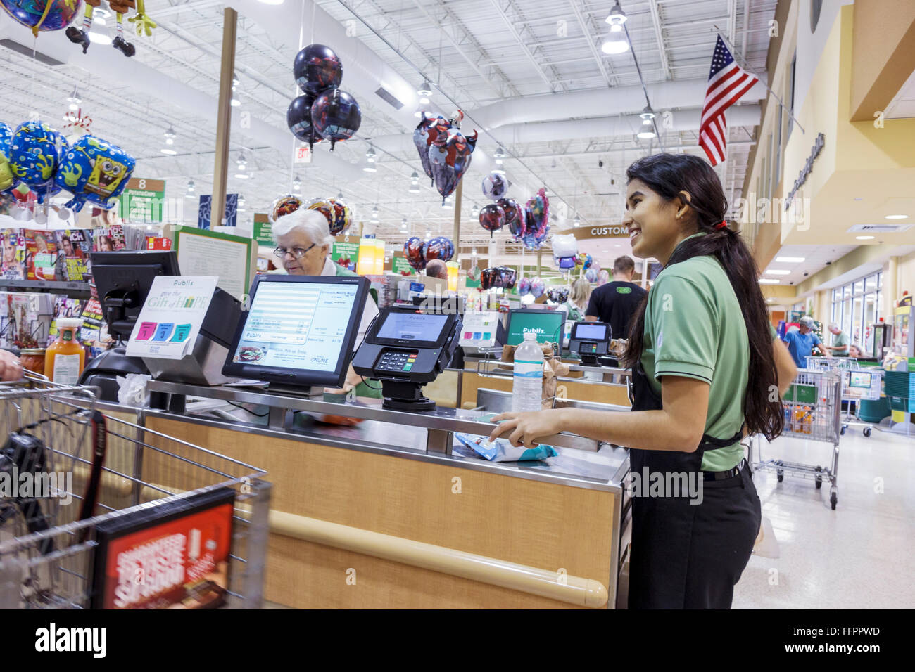 Florida Ocala Publix negozio di alimentari supermercato checkout cassiere bagger, ispanico teen adolager ragazza lavoratrice dipendente, Foto Stock
