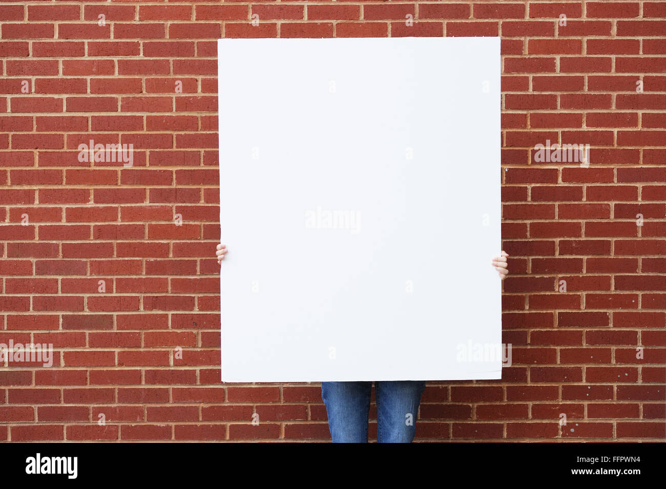 Blank Board tiene pronti per il testo di fronte a un muro di mattoni Foto Stock
