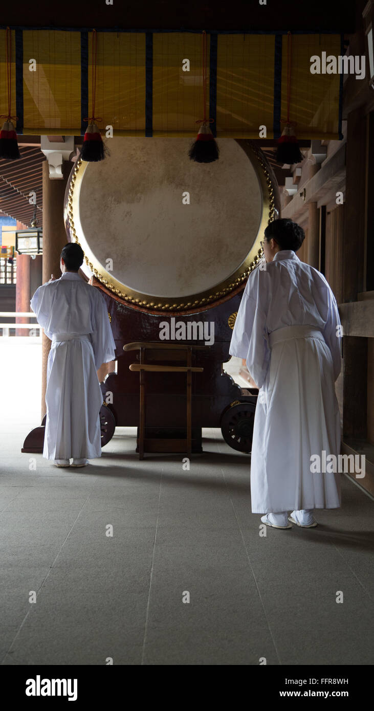 Lo Shintoismo sacerdoti prepararsi a colpire il tamburo al Tempio di Meiji per un rituale. Foto Stock