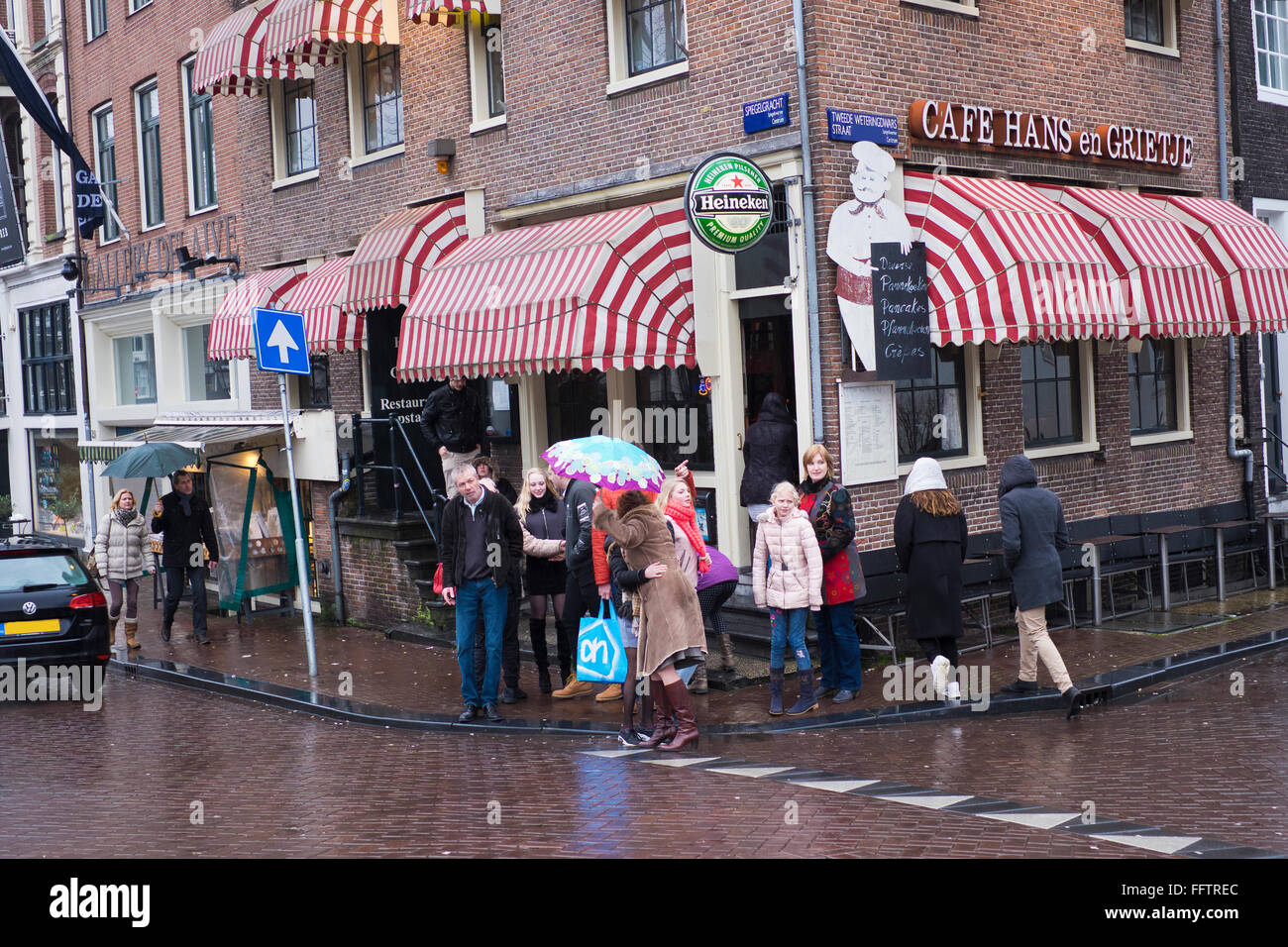 Turisti lasciano un cafe in area centruml di Amsterdam su un inverno umido del giorno, Paesi Bassi Foto Stock