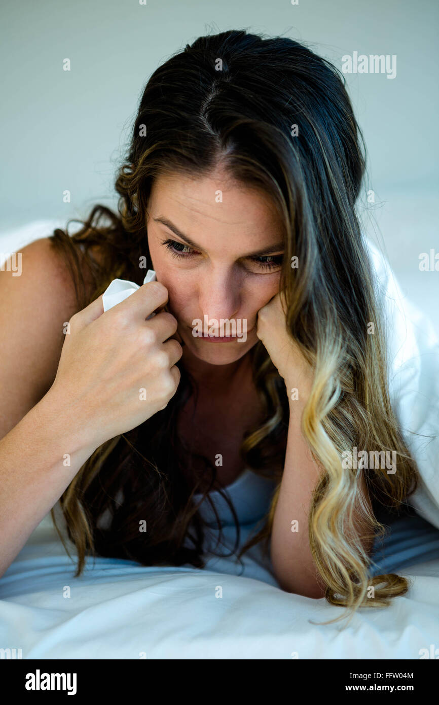 Donna che mantiene un tessuto e guardando sconvolto Foto Stock