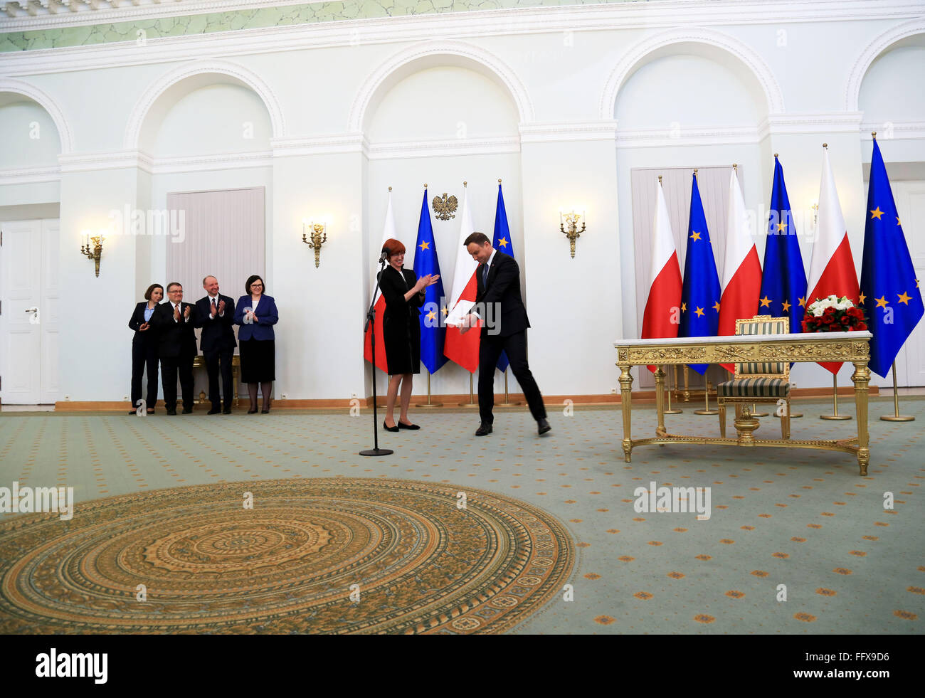 Presidente polacco Andrzej Duda e ministro della famiglia, del lavoro e della politica sociale El?bieta Rafalska mostra la nuova legge firmata, 500 , che dovrebbe consentire al governo di aiutare le famiglie con il costo di allevare i figli, consentendo alle famiglie di ottenere 500 zloti (125 dollari) per ogni primo e secondo figlio in una famiglia. Il Presidente ha firmato la legge in legge nel corso di una cerimonia. Il Ministro della famiglia, del lavoro e della politica sociale El?bieta Rafalska (prima a destra) hanno partecipato, come pure il capo della cancelleria del Presidente, Ma?gorzata Sadurska (secondo da destra). La legge è stata elaborata come bandiere Foto Stock