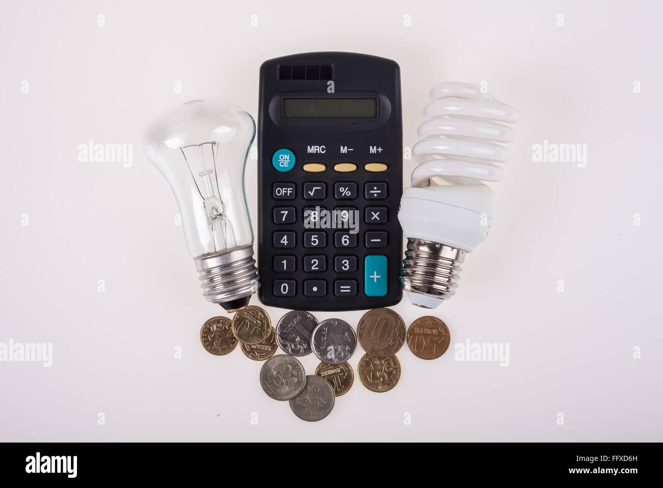 Risparmio energetico, lampade standard e calcolatrice su sfondo bianco Foto Stock