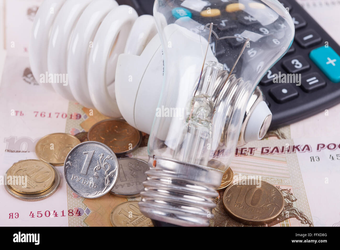 Concetto di risparmio energetico. Lampadina elettrica, ruble denaro e calcolatrice Foto Stock