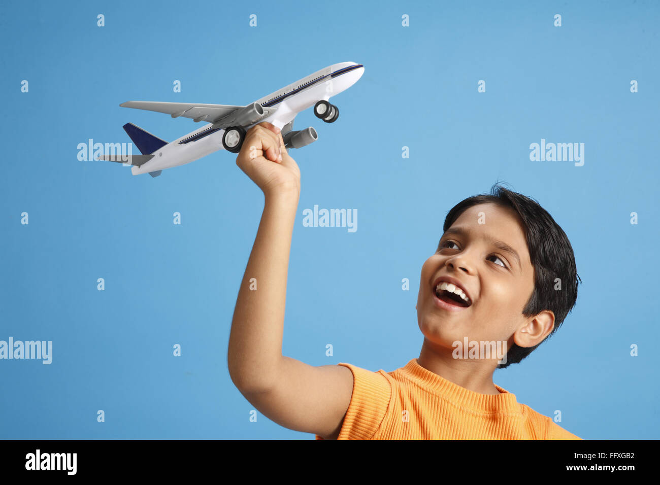Dieci anni di old boy holding toy piano in mano e cercano di volare è il signor#703V Foto Stock