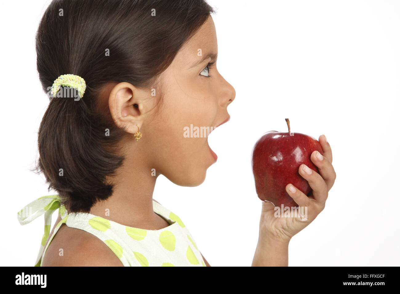 8 anno vecchia ragazza azienda red apple in una mano e il pensiero di mangiare il signor#703U Foto Stock