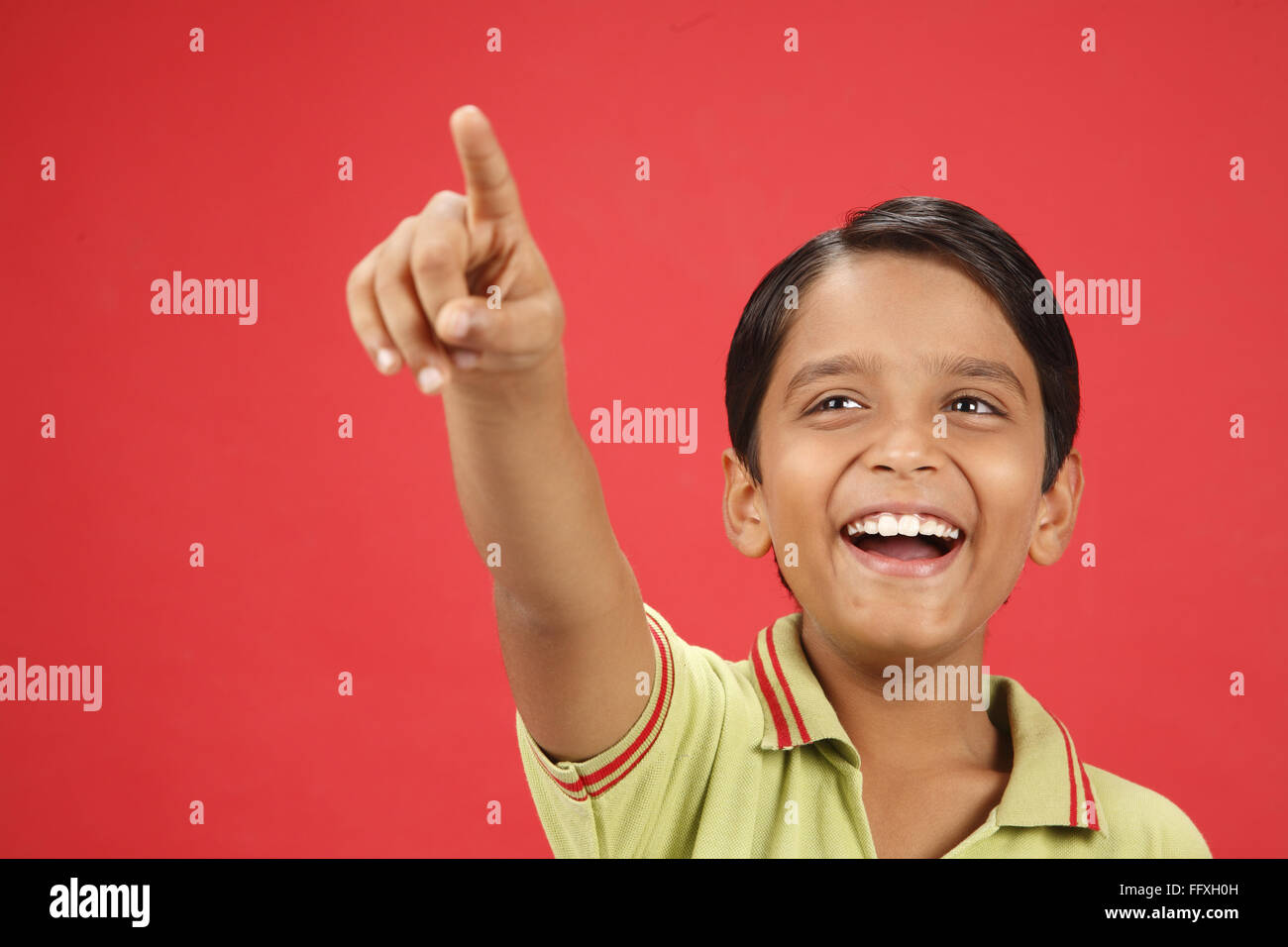 Dieci anni di vecchio ragazzo che mostra qualcosa verso l'alto con il dito indice signor#703V Foto Stock