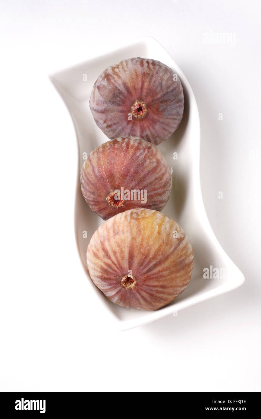 Frutta , Figg mantenuta nella forma s piastra bianca Ficus carica Anjir su sfondo bianco Foto Stock