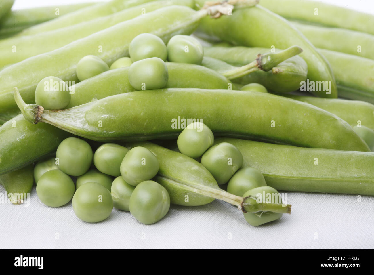 , Vegetale piselli verdi pod Pisum sativum con piselli unpeel su sfondo bianco Foto Stock