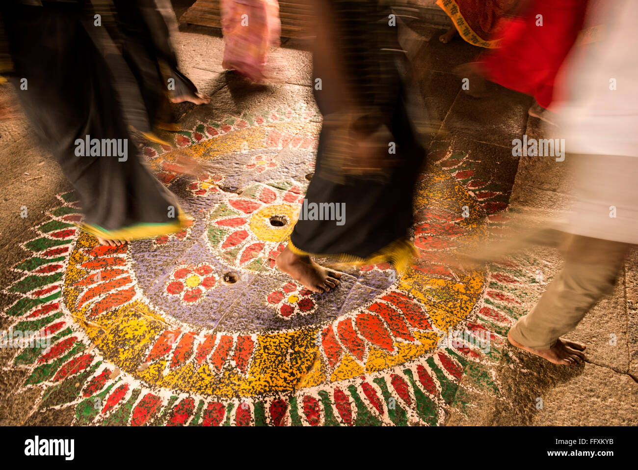 I piedi di pellegrini camminando su un design colorato al Ekambareswara tempio indù di Kanchipuram, Tamil Nadu, India Foto Stock