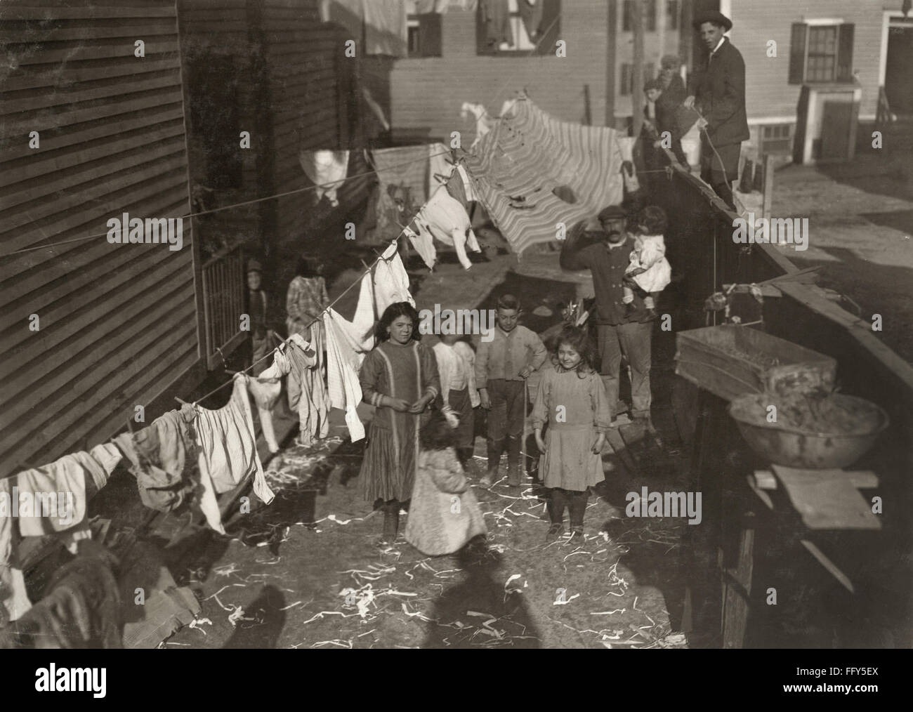 HINE: gabbia di laminazione, 1912. /NTextile mill lavoratore la famiglia  nel cortile con uno stendibiancheria coperto con servizio lavanderia di  Providence, Rhode Island. Fotografia di Lewis Hine, novembre 1912 Foto  stock - Alamy