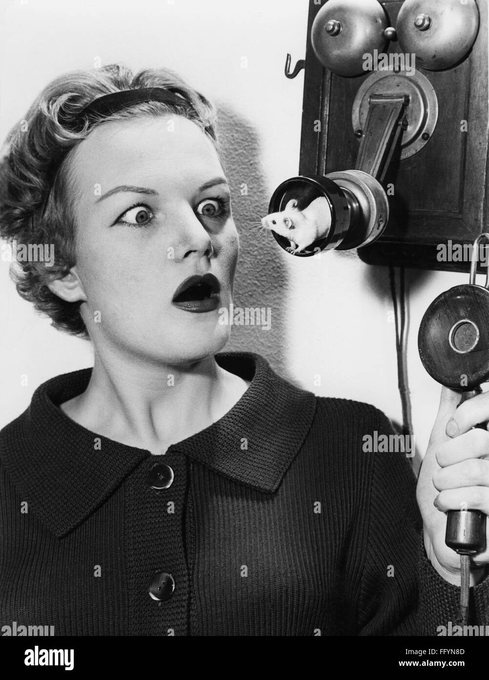 Stranezze, donna che osserva il mouse in un boccaglio di un vecchio telefono, anni '50, diritti aggiuntivi-clearences-non disponibile Foto Stock