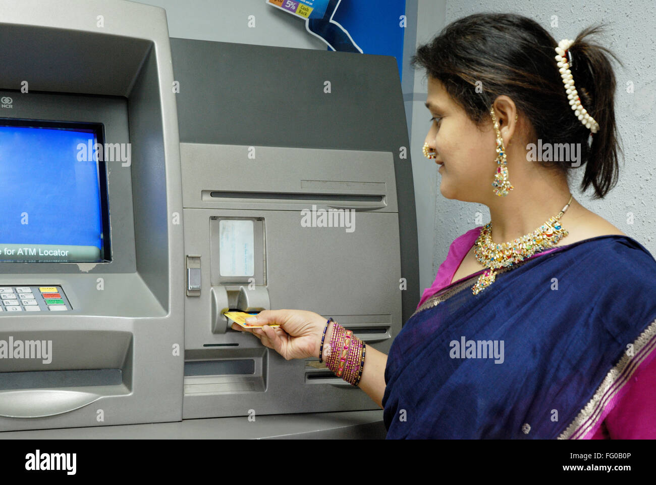 Signora utilizzando carta bancomat per prelevare denaro dal conto di risparmio a mutilare , Bombay Mumbai , Maharashtra , India Signor#721S Foto Stock