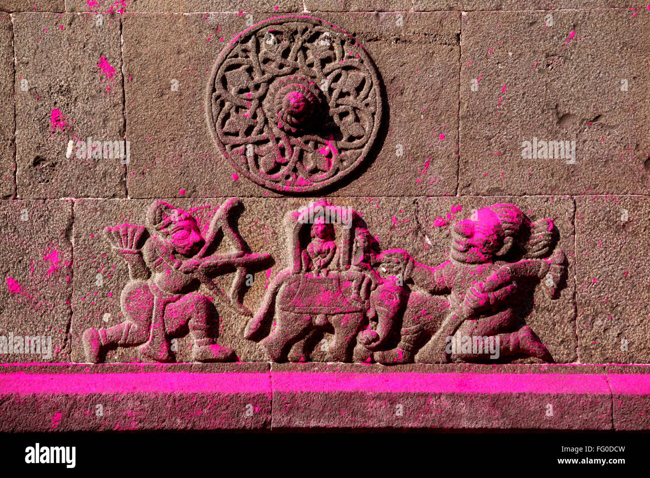 Opere d'arte sul muro del tempio Jotiba immerso in gulal luminose sfumature di rosa polvere villaggio Kolhapur Wadi Ratnagiri Maharashtra Foto Stock