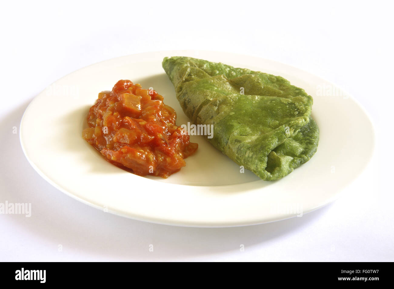 La cucina indiana , fast food Palak croccanti Spinaci Puri con pomodori masala bhaji o sabzi servita nel piatto su sfondo bianco Foto Stock