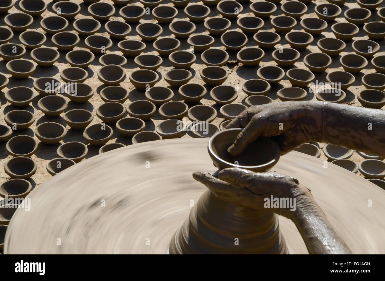 Potter rendendo le lampade di argilla sulla ruota di ceramiche Jodhpur Rajasthan in India Foto Stock