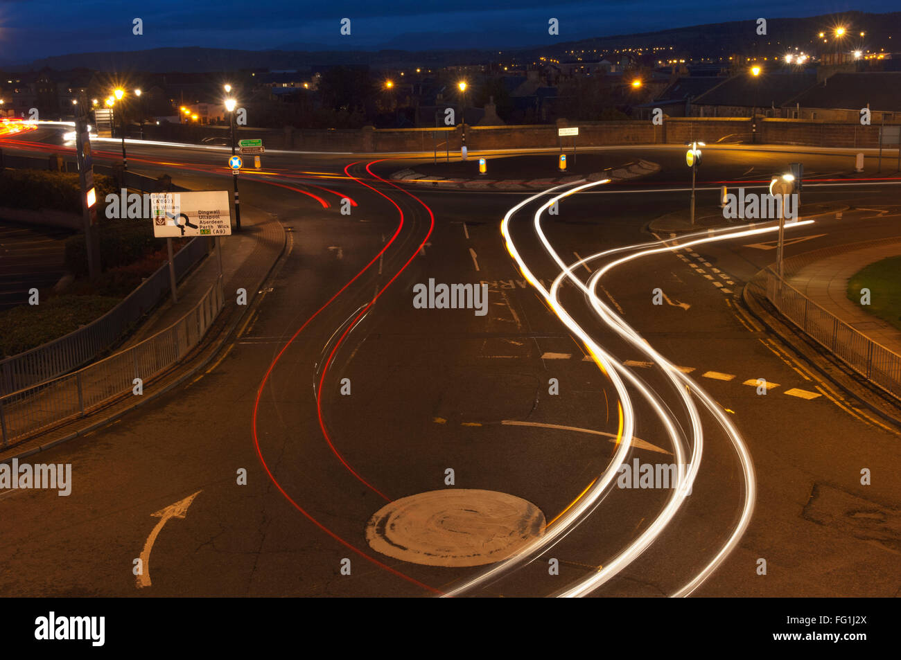 Auto sentieri di luce di notte, in corrispondenza di una serie di rotatorie a Inverness, Scotland. Foto Stock