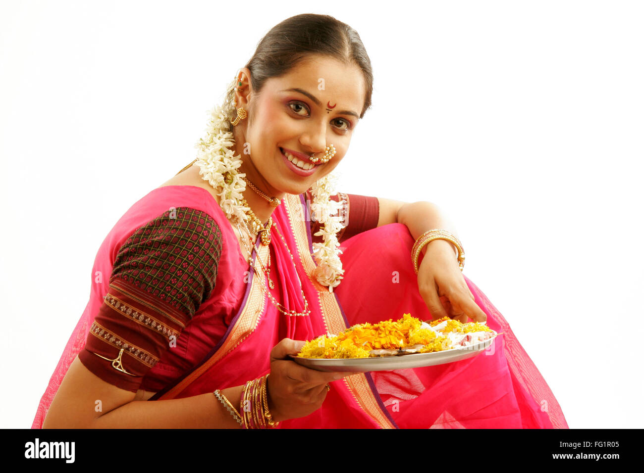 South Asian Indian Maharashtrian ragazza indossando il tradizionale navwari sari appropriate jewelry gajra holding pooja Thali Foto Stock