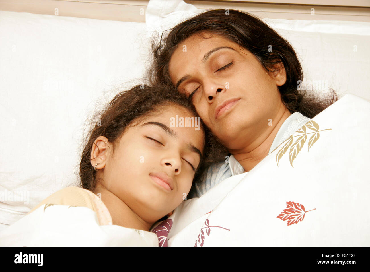 South Asian Indian madre e figlia avente suono addormentato sul letto signor#191,189 Foto Stock